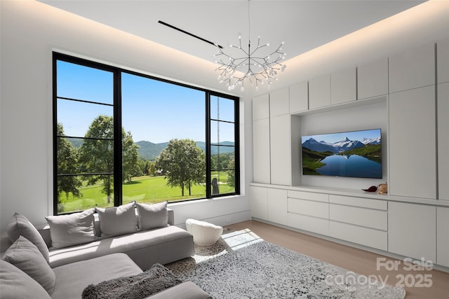 living room with light wood-type flooring and a chandelier