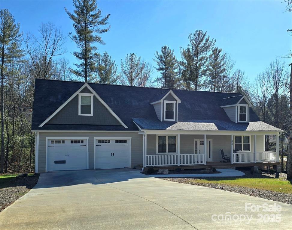 view of front of home featuring driveway, an attached garage, and a porch