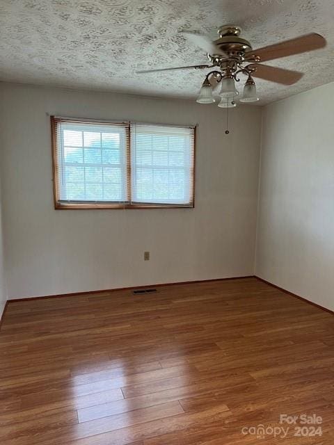 unfurnished room featuring ceiling fan, a textured ceiling, and wood-type flooring