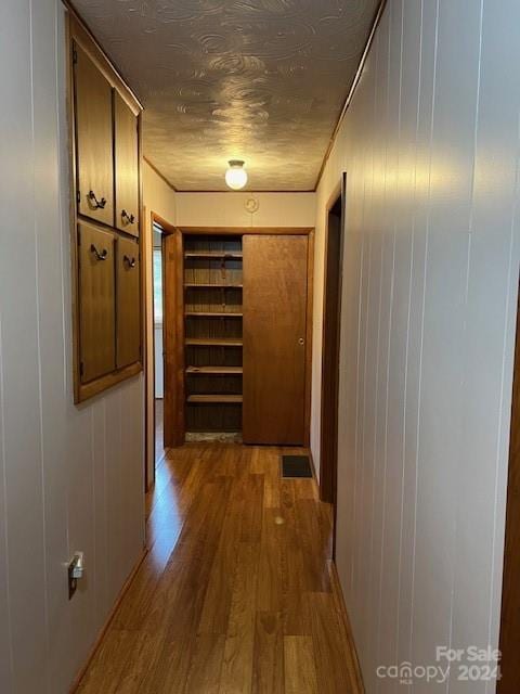 corridor featuring wood walls and hardwood / wood-style flooring