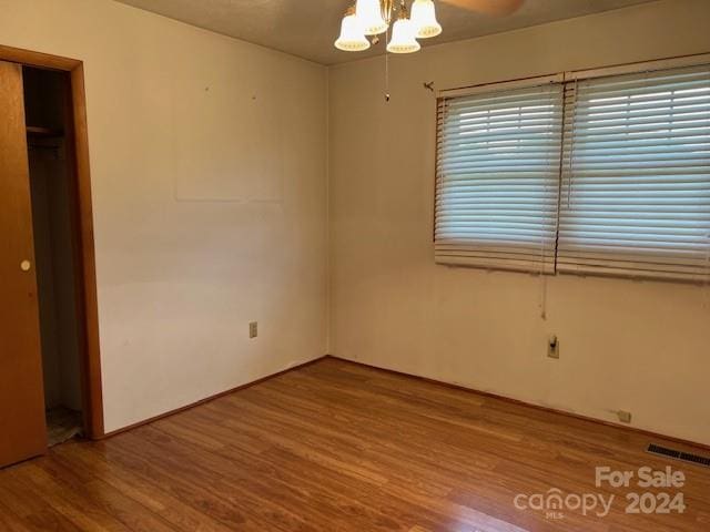 unfurnished bedroom featuring wood-type flooring, a closet, and a walk in closet