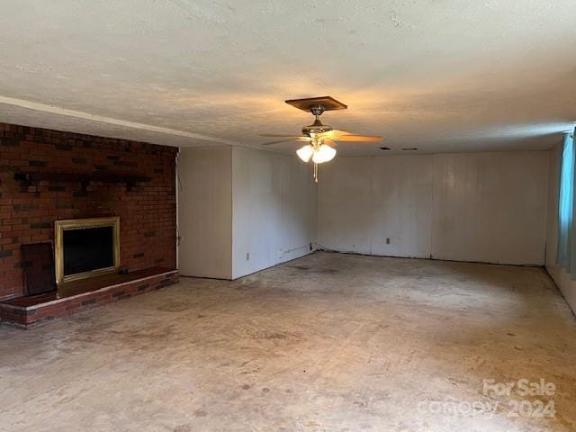 unfurnished living room featuring ceiling fan and a fireplace