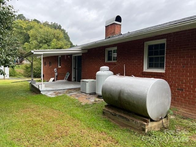 back of property with a yard and a patio