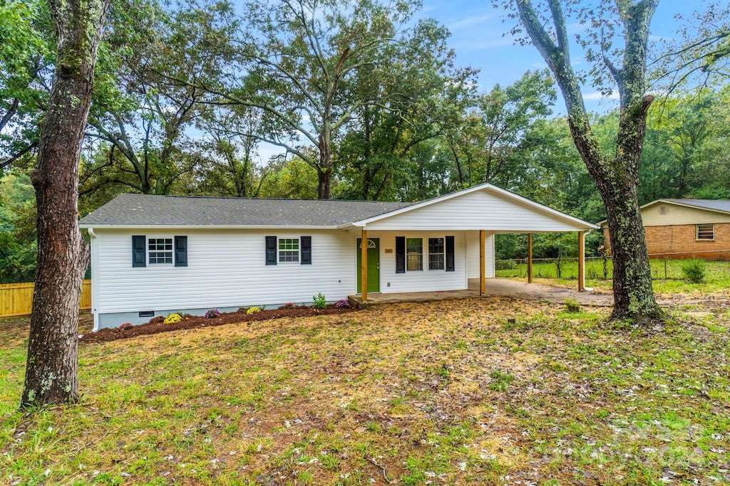 ranch-style home with a front lawn and a patio area