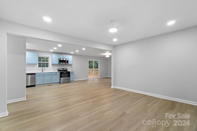 unfurnished living room with light hardwood / wood-style floors and sink