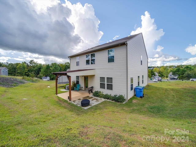 rear view of property featuring a lawn and a patio area