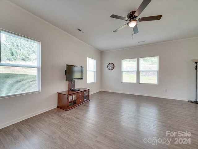 unfurnished living room featuring wood-type flooring, crown molding, and ceiling fan