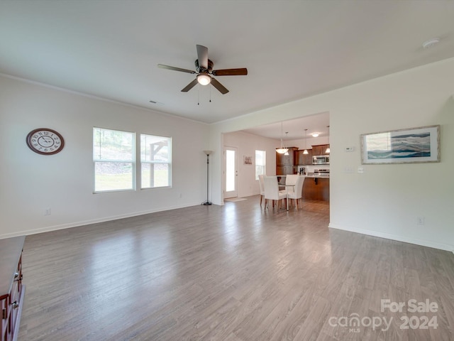 unfurnished living room featuring ceiling fan and hardwood / wood-style floors