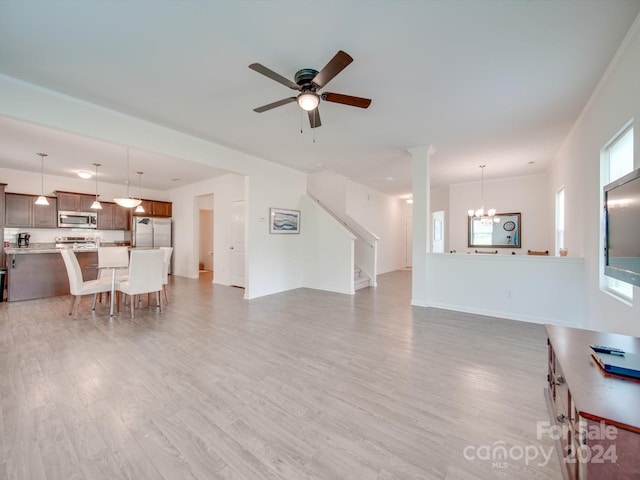 living room featuring ceiling fan with notable chandelier and hardwood / wood-style floors