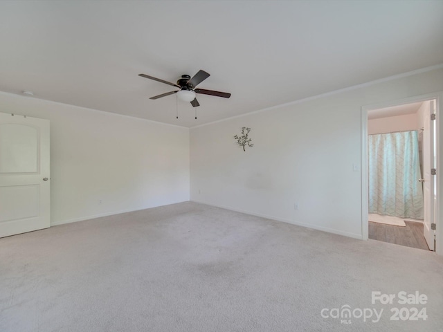 empty room featuring crown molding, ceiling fan, and light colored carpet