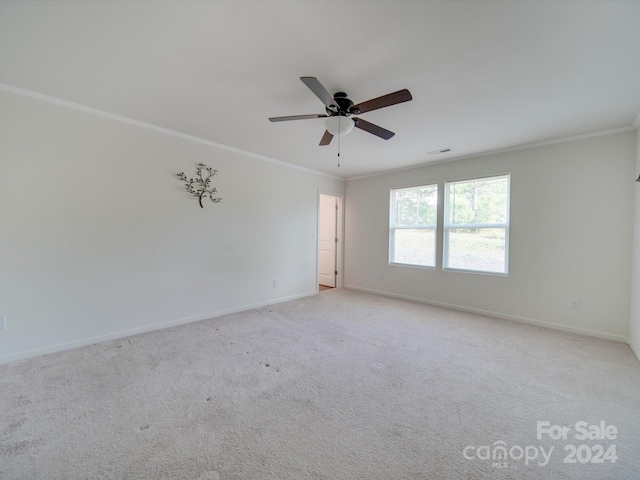 carpeted empty room featuring ceiling fan and crown molding