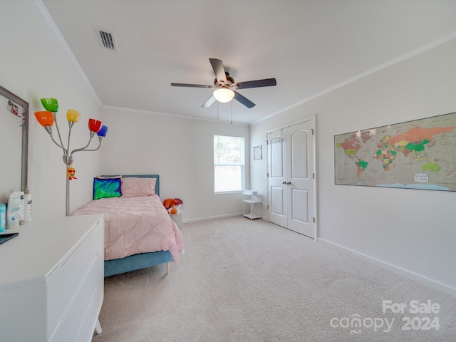 carpeted bedroom with crown molding, ceiling fan, and a closet