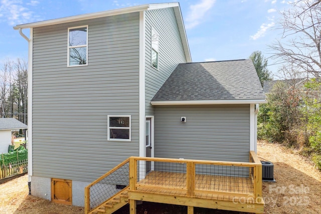 rear view of property featuring a deck, central AC, and roof with shingles