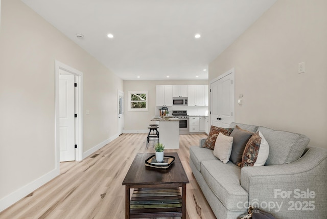 living area with recessed lighting, light wood-type flooring, and baseboards