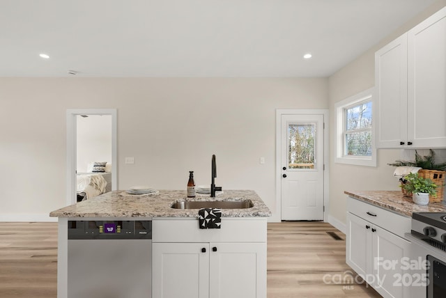 kitchen featuring light stone counters, a kitchen island with sink, a sink, white cabinetry, and stainless steel dishwasher