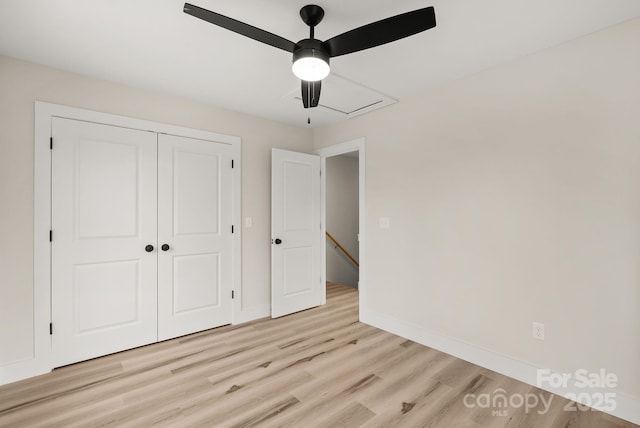 unfurnished bedroom with baseboards, a closet, and light wood-style floors