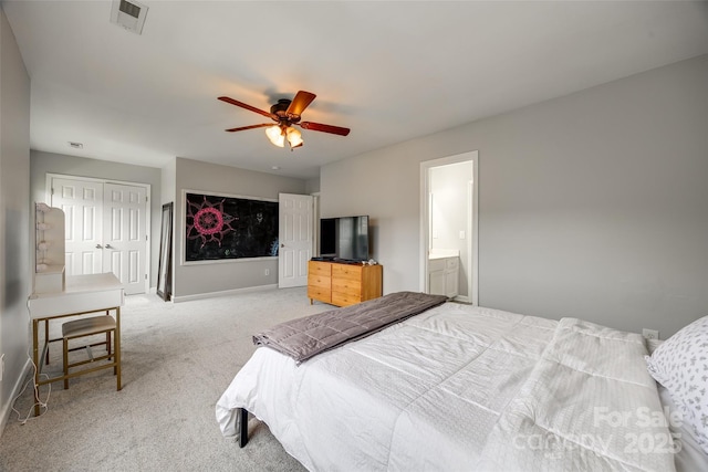 bedroom featuring visible vents, baseboards, ceiling fan, light colored carpet, and ensuite bathroom