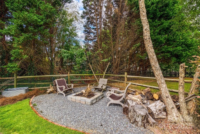 view of yard featuring an outdoor fire pit and fence