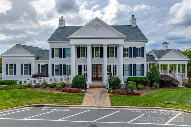 exterior space featuring french doors, a lawn, and a chimney