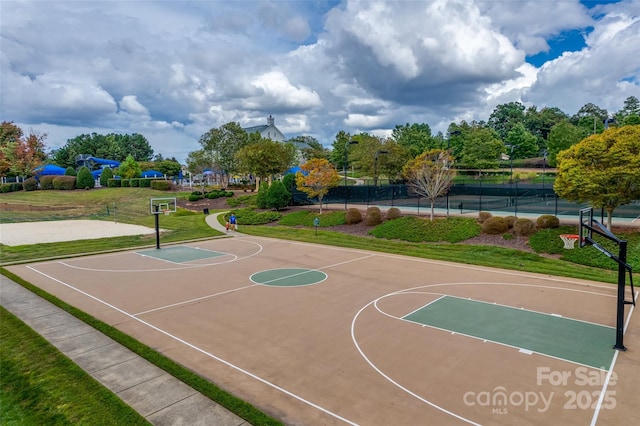 view of basketball court with a lawn, community basketball court, and fence