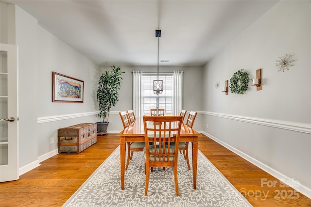 dining space featuring light wood finished floors and baseboards