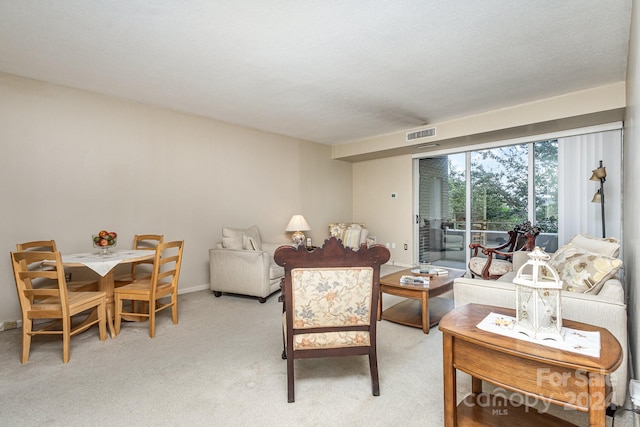 living room with a textured ceiling and light colored carpet