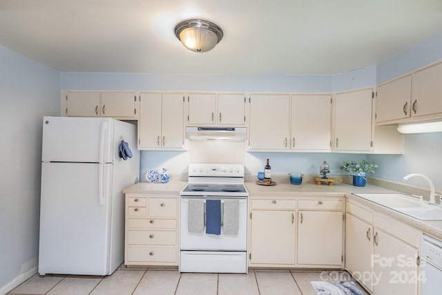 kitchen featuring white appliances, cream cabinets, light tile patterned flooring, and sink