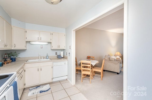 kitchen with stainless steel stove, light colored carpet, dishwasher, and sink