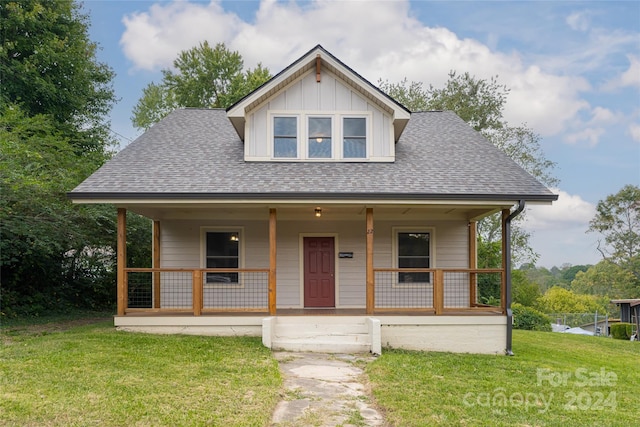 view of front of house featuring covered porch and a front lawn