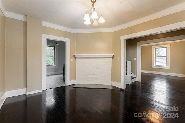 unfurnished room with ornamental molding, dark wood-type flooring, a chandelier, and plenty of natural light