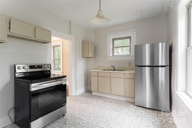 kitchen with a wealth of natural light, sink, appliances with stainless steel finishes, and cream cabinetry