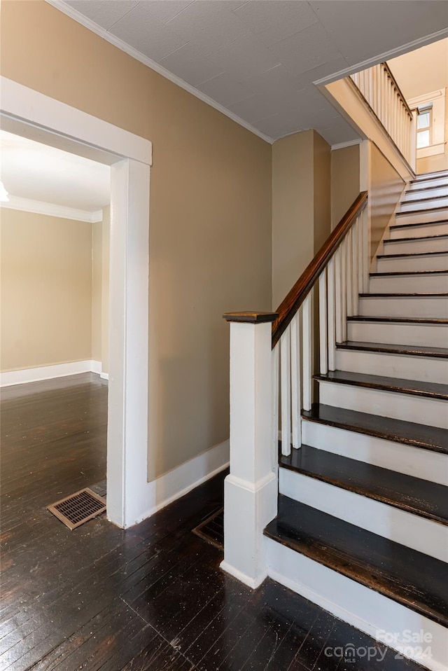 stairway with crown molding and hardwood / wood-style flooring