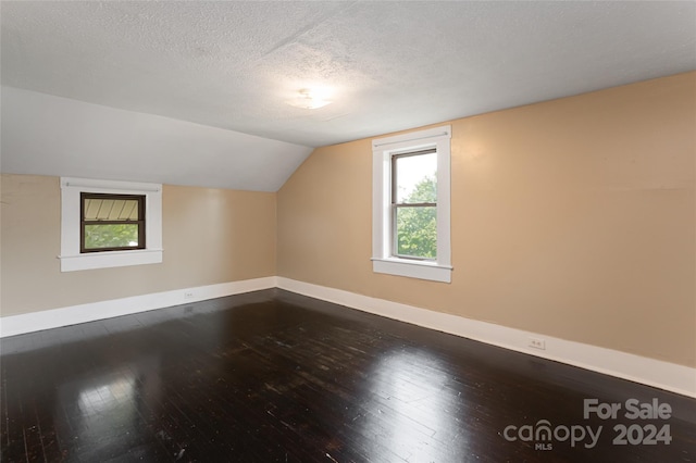 bonus room with hardwood / wood-style floors, a textured ceiling, and vaulted ceiling