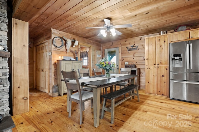 dining room with wood walls, ceiling fan, wood ceiling, and light hardwood / wood-style floors