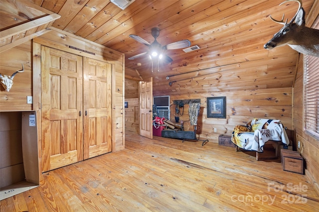 interior space featuring hardwood / wood-style floors, ceiling fan, wooden ceiling, and wooden walls