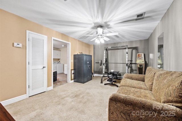 carpeted living room with ceiling fan and independent washer and dryer