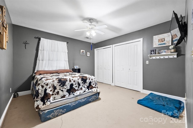 bedroom featuring ceiling fan, concrete flooring, and two closets