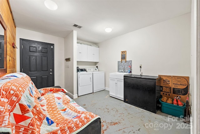 clothes washing area featuring cabinets and independent washer and dryer