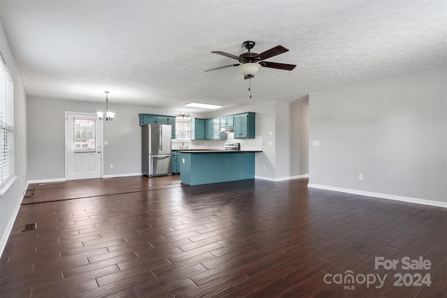 unfurnished living room featuring a textured ceiling, ceiling fan with notable chandelier, and dark hardwood / wood-style floors