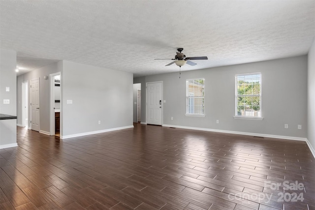 empty room with a textured ceiling and dark hardwood / wood-style flooring