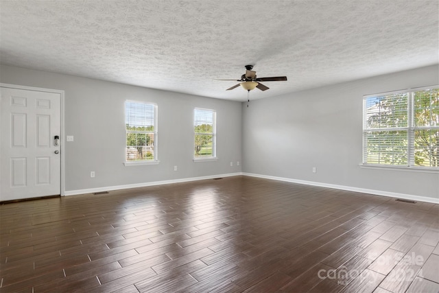 spare room featuring ceiling fan, dark wood-type flooring, and a textured ceiling