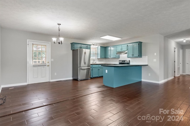 kitchen with kitchen peninsula, a textured ceiling, decorative light fixtures, appliances with stainless steel finishes, and dark hardwood / wood-style floors