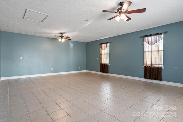 unfurnished room featuring a textured ceiling, light tile patterned floors, and ceiling fan