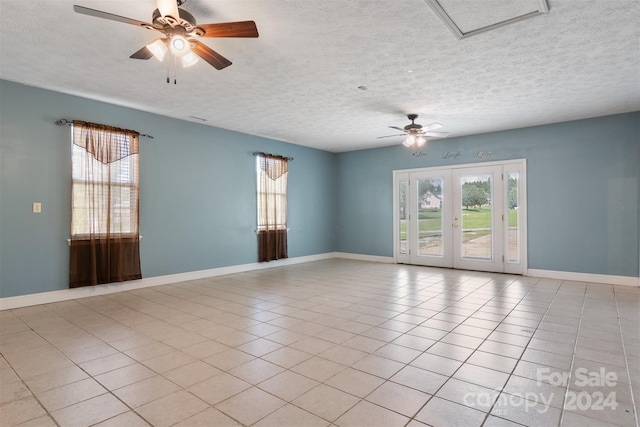 tiled empty room with ceiling fan, french doors, and a textured ceiling