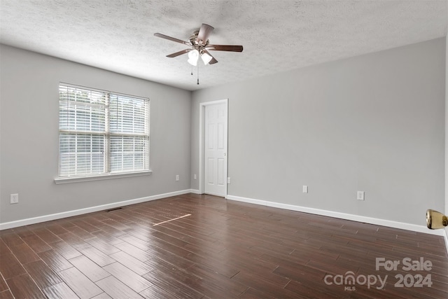 spare room with a textured ceiling, ceiling fan, and dark hardwood / wood-style flooring