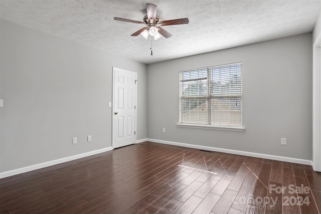 empty room with a textured ceiling, dark hardwood / wood-style flooring, and ceiling fan