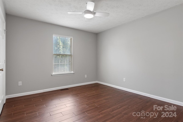 empty room featuring a textured ceiling, ceiling fan, and dark wood-type flooring