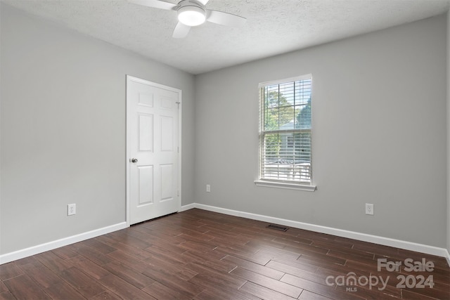 empty room featuring ceiling fan, a textured ceiling, and dark hardwood / wood-style flooring