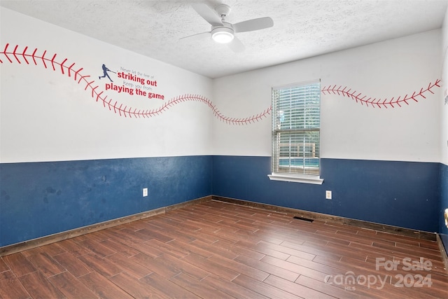 empty room featuring ceiling fan, a textured ceiling, and dark hardwood / wood-style flooring