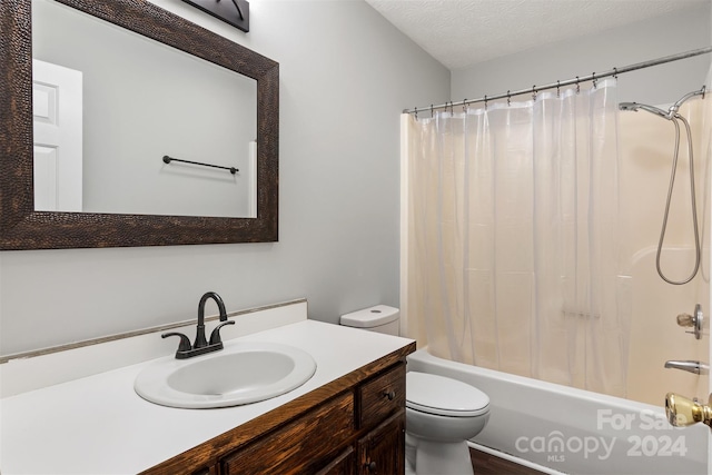 full bathroom featuring shower / tub combo, vanity, a textured ceiling, hardwood / wood-style flooring, and toilet